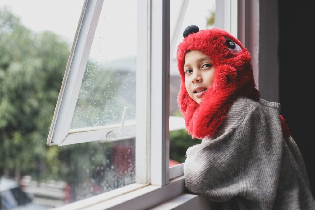 Boy standing near the windows on winter