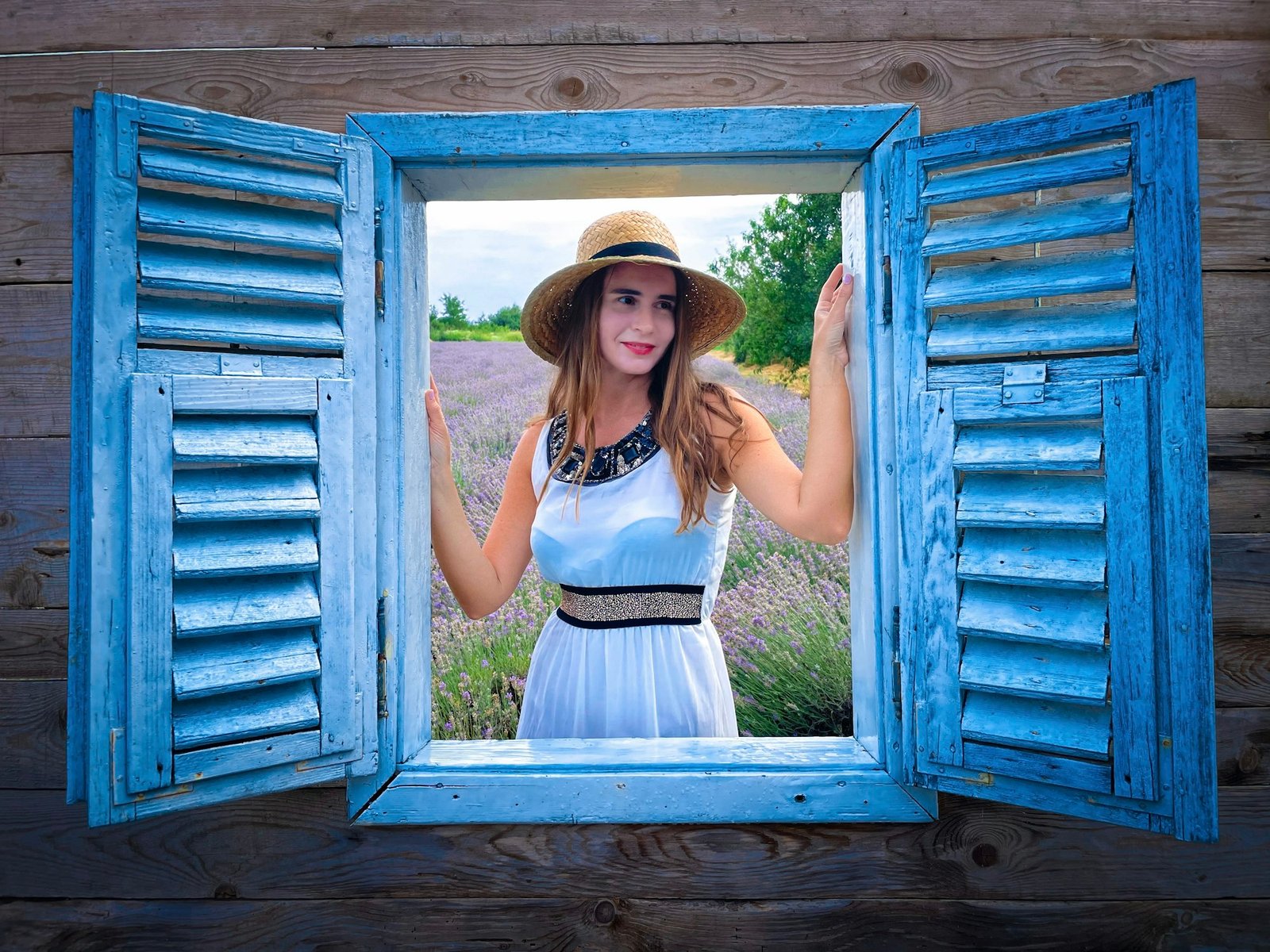 Fashionable woman wearing summer dress and hat looking through the window