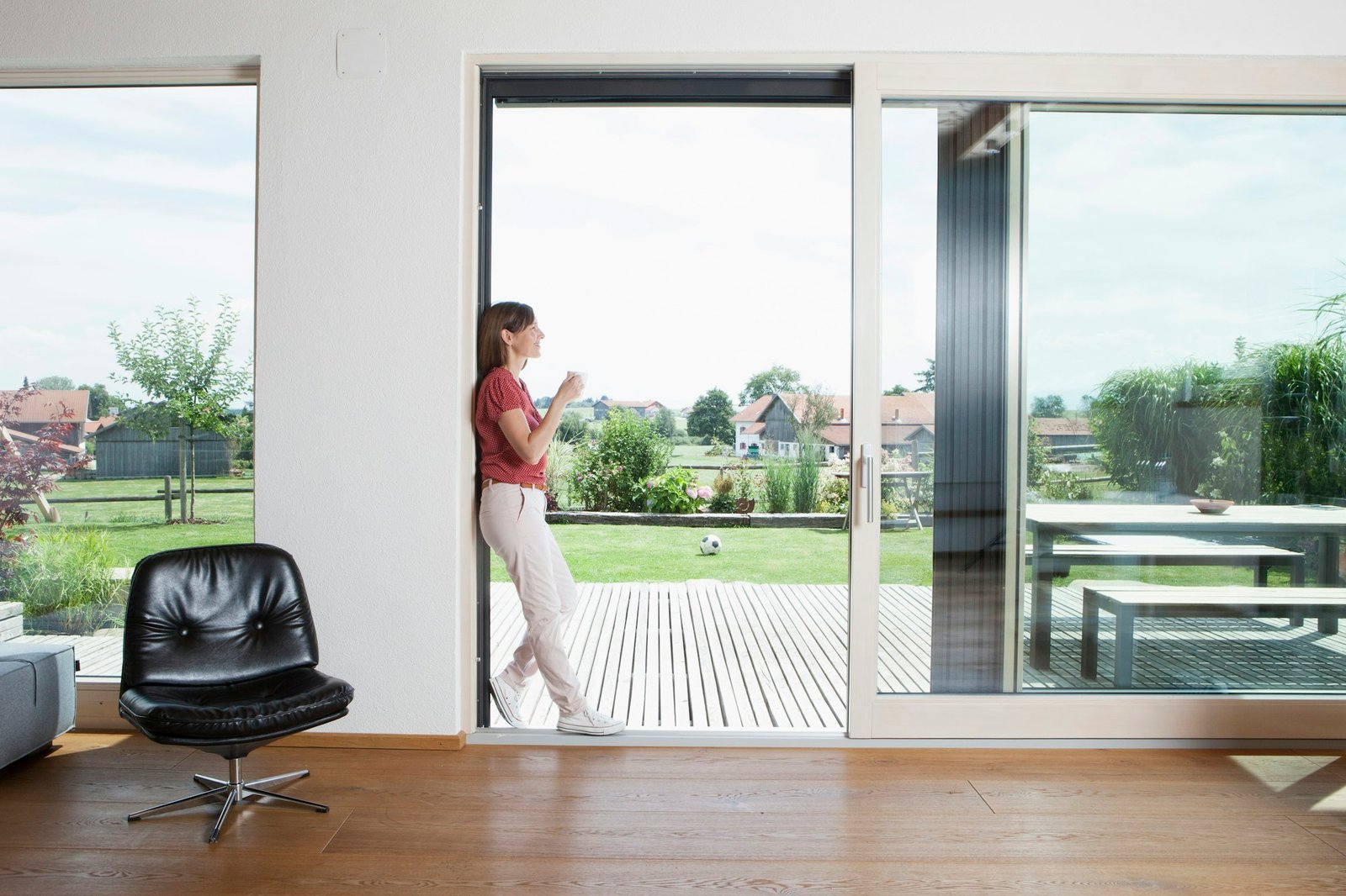 Mature couple leaning in garden door with cup of coffee