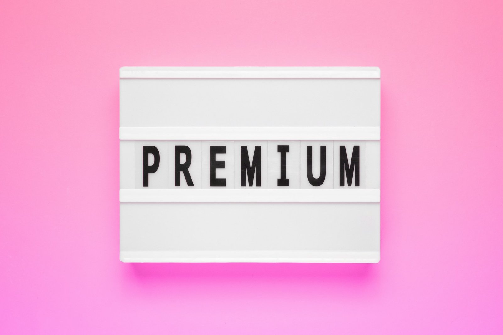 The word premium on lightbox isolated pink background. Premium Membership Concept.