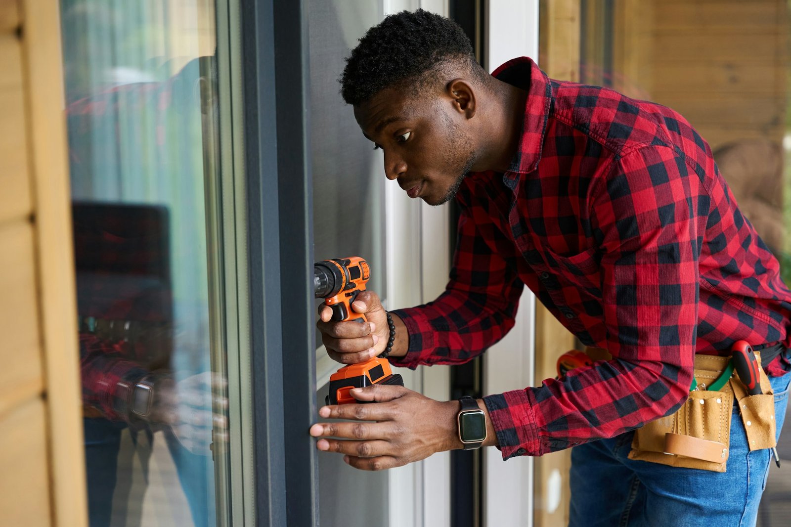 African American man repairs a glass door